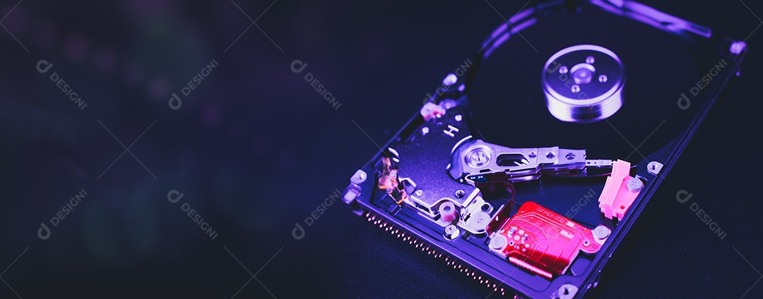 Unidade de disco rígido aberta desmontada HDD de computador ou laptop encontra-se na superfície fosca escura.