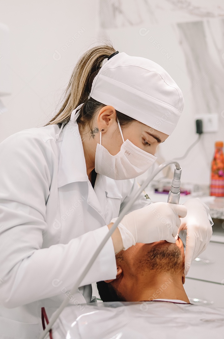 Dentista sobre seu consultorio odontológico atendendo seu paciente