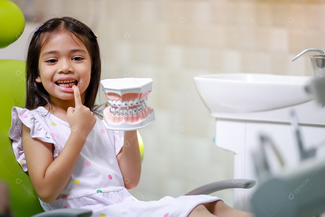 Esta linda garota está se preparando para sua consulta odontológica regular no check-up do consultório do dentista.