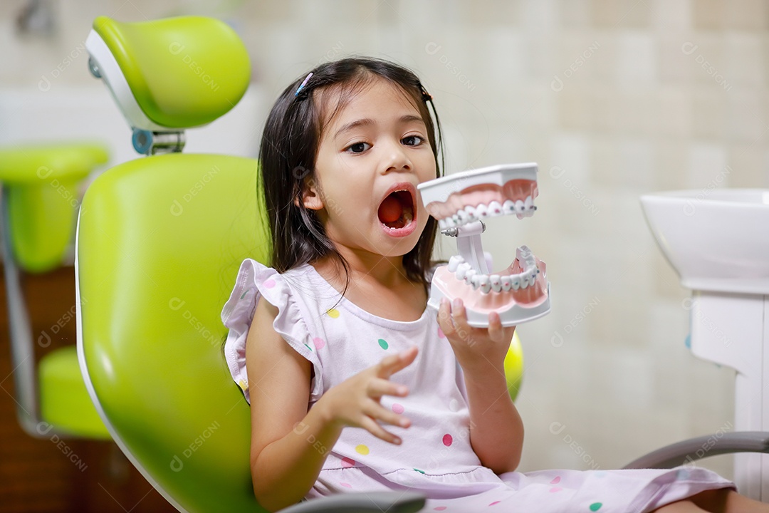 Esta linda garota está se preparando para sua consulta odontológica regular no check-up do consultório do dentista.