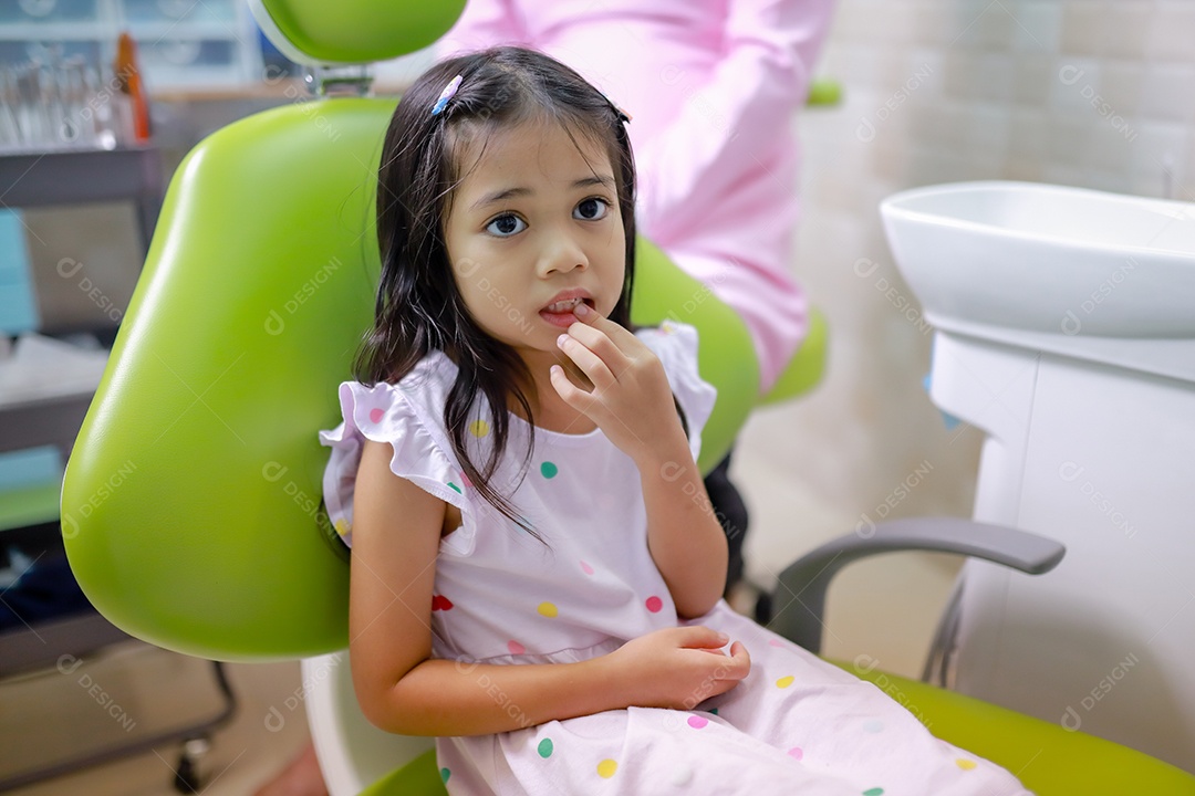 Esta linda garota está se preparando para sua consulta odontológica regular no check-up do consultório do dentista.