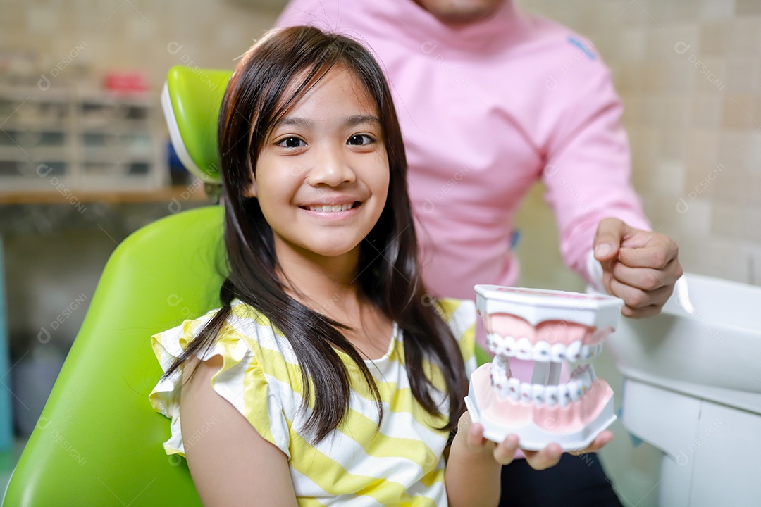 Esta linda garota está se preparando para sua consulta odontológica regular no check-up do consultório do dentista.