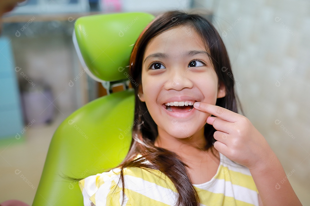 Esta linda garota está se preparando para sua consulta odontológica regular no check-up do consultório do dentista.