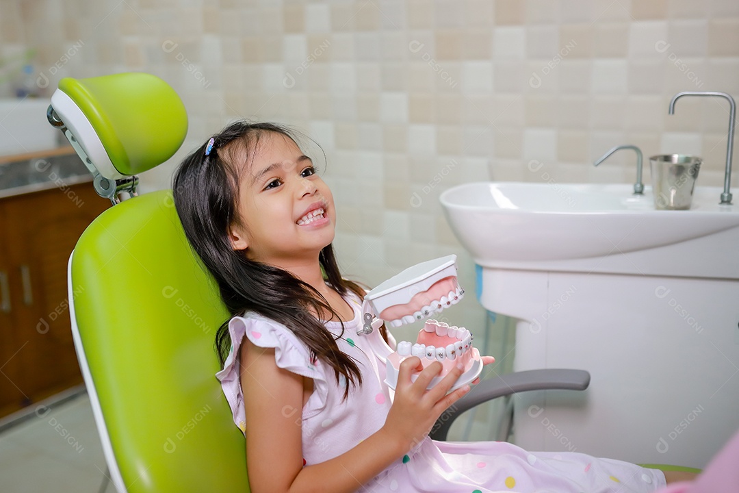 Esta linda garota está se preparando para sua consulta odontológica regular no check-up do consultório do dentista.