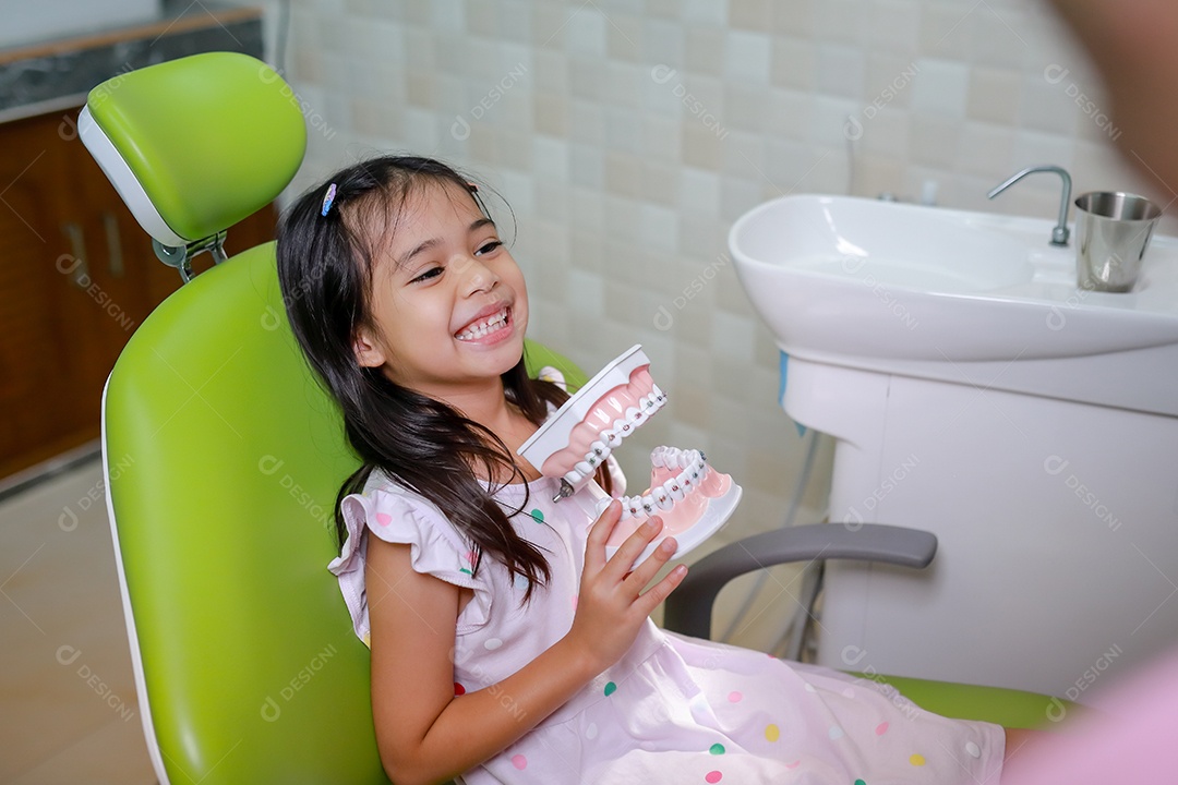 Esta linda garota está se preparando para sua consulta odontológica regular no check-up do consultório do dentista.