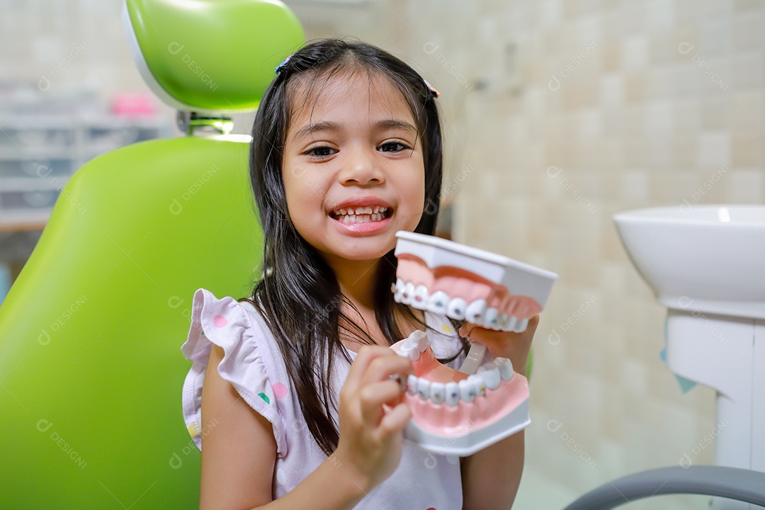 Esta linda garota está se preparando para sua consulta odontológica regular no check-up do consultório do dentista.