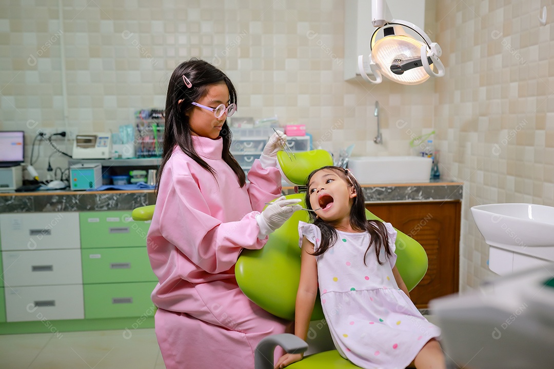 Esta linda garota está se preparando para sua consulta odontológica regular no check-up do consultório do dentista.