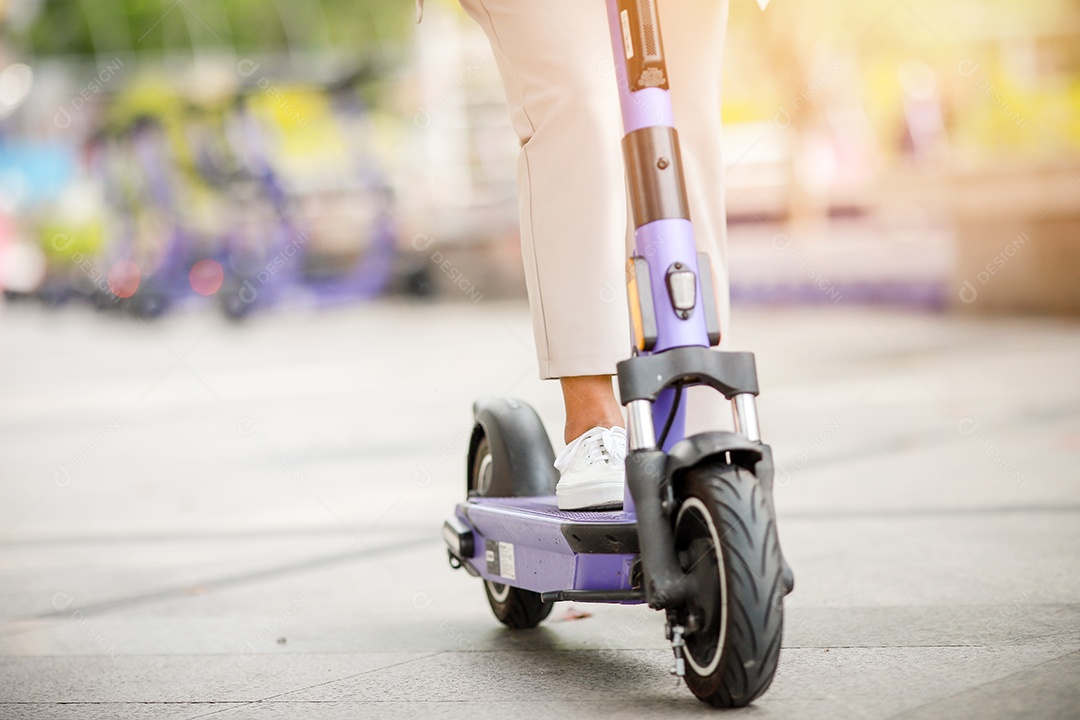 Senhora elegante de terno anda de scooter elétrica para trabalhar