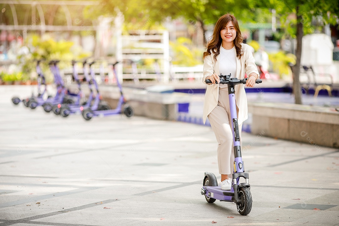 Senhora elegante de terno anda de scooter elétrica para trabalhar