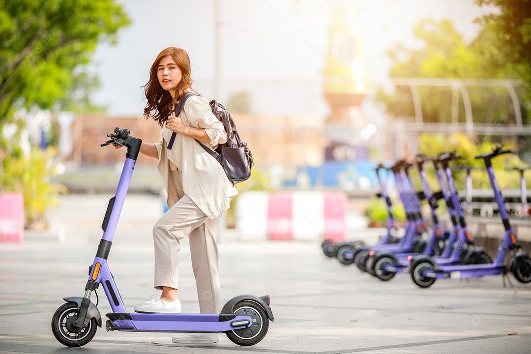 Senhora elegante de terno anda de scooter elétrica para trabalhar