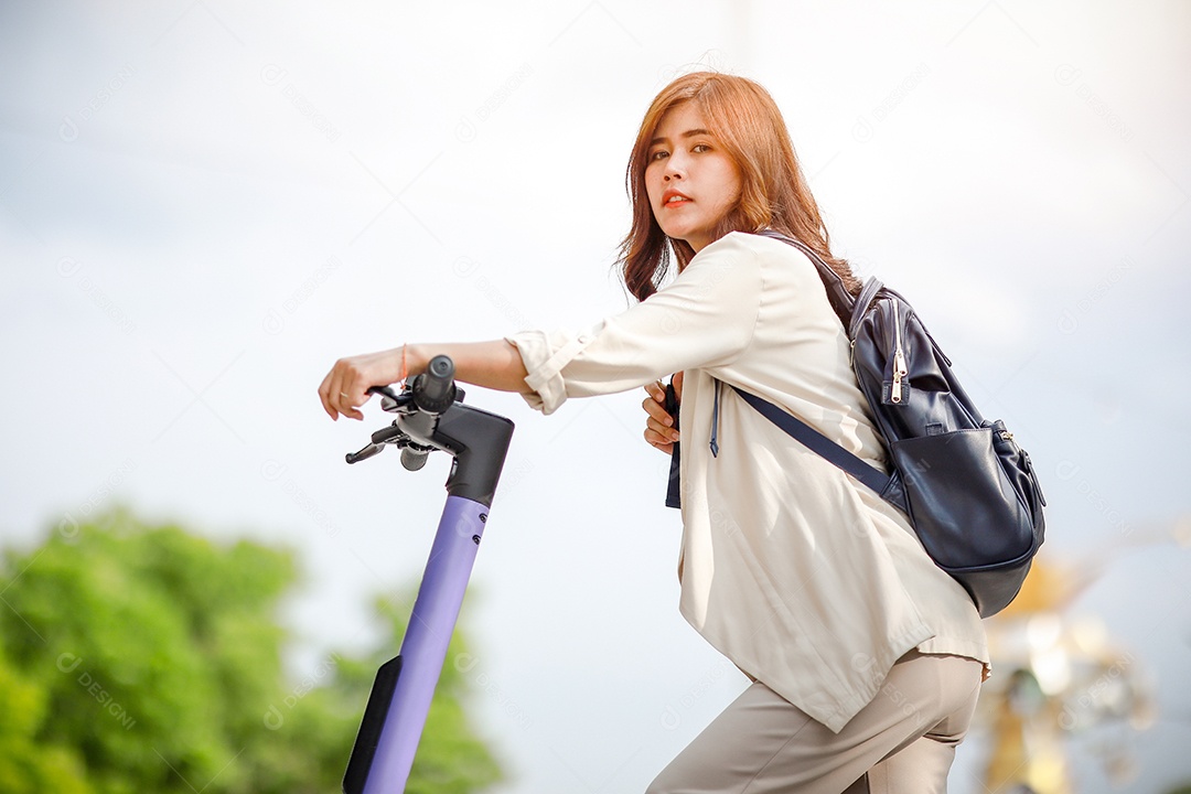 Senhora elegante de terno anda de scooter elétrica para trabalhar