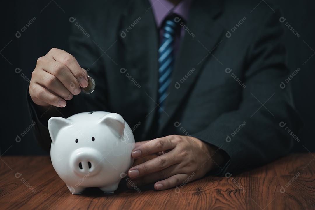 empresário segurando moedas colocando no cofrinho. conceito economizando dinheiro para contabilidade financeira.