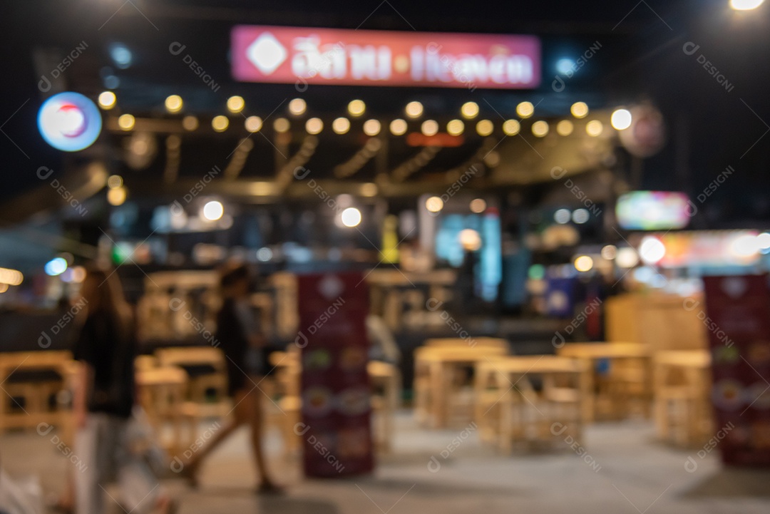 Desfoque o festival de rua de comida de fundo da pessoa no mercado noturno.