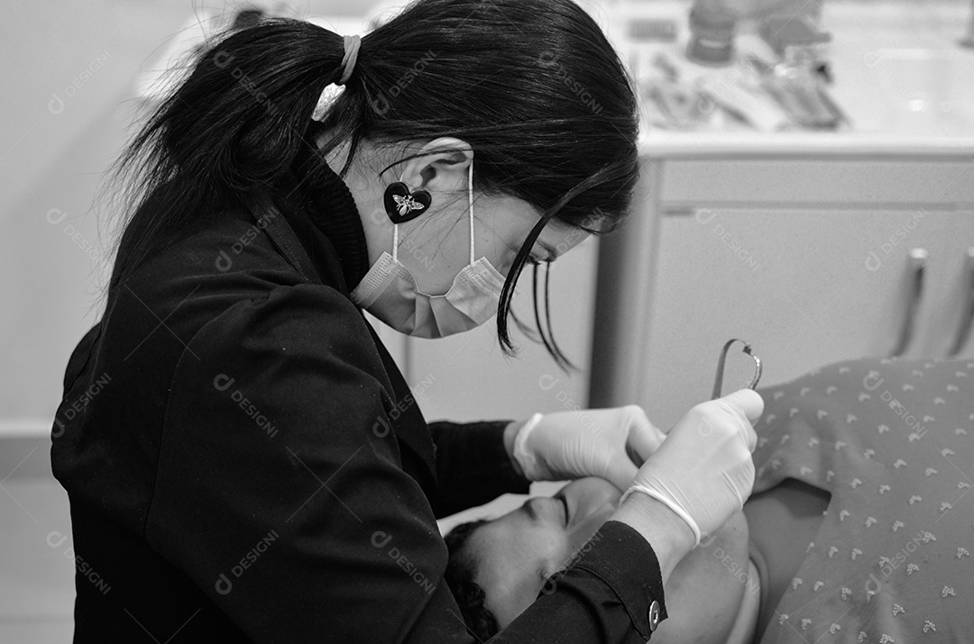 Dentista sobre seu consultorio odontológico atendendo seu paciente