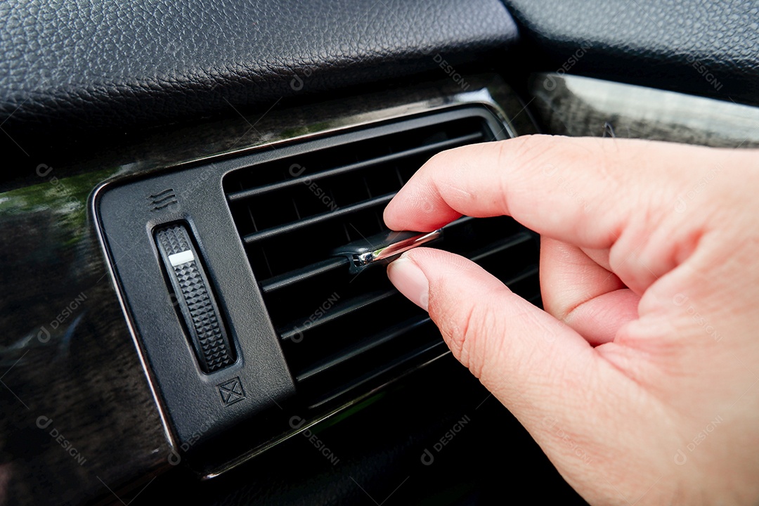 Mão de uma pessoa ajustando ar condicionado