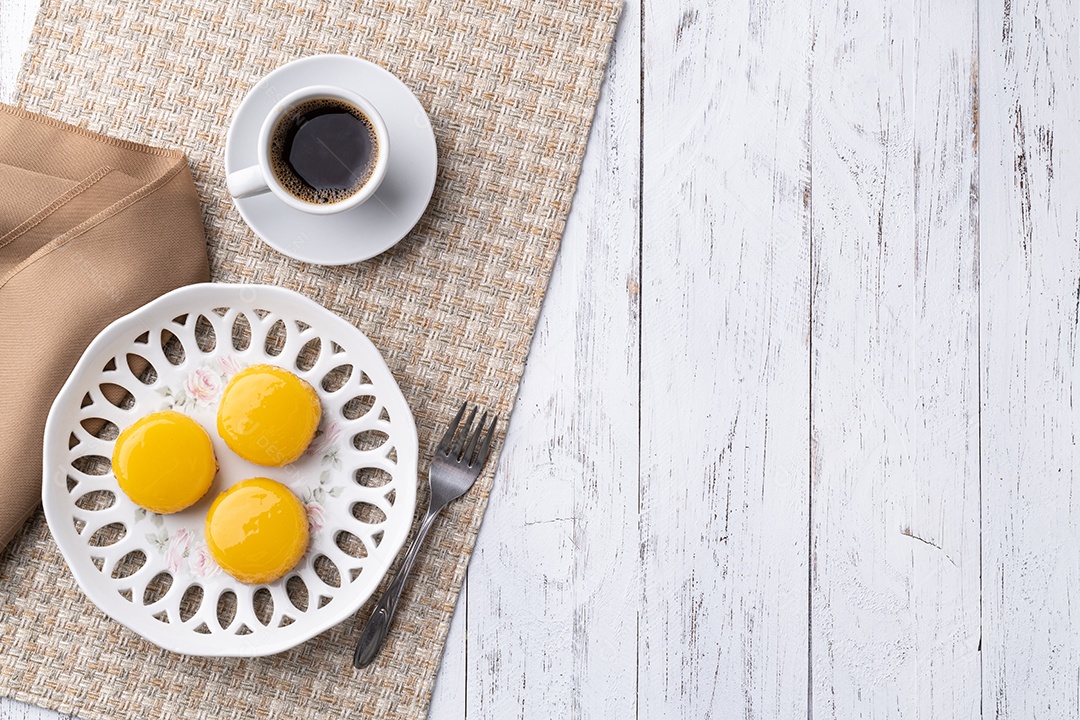 Quindim, tradicional sobremesa brasileira de ovo e coco com espaço para café e cópia.