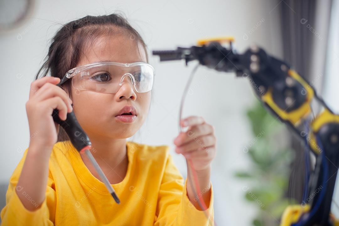 Conceito de educação STEM. Estudantes asiáticos aprendem em casa codificando braços de robôs em STEM