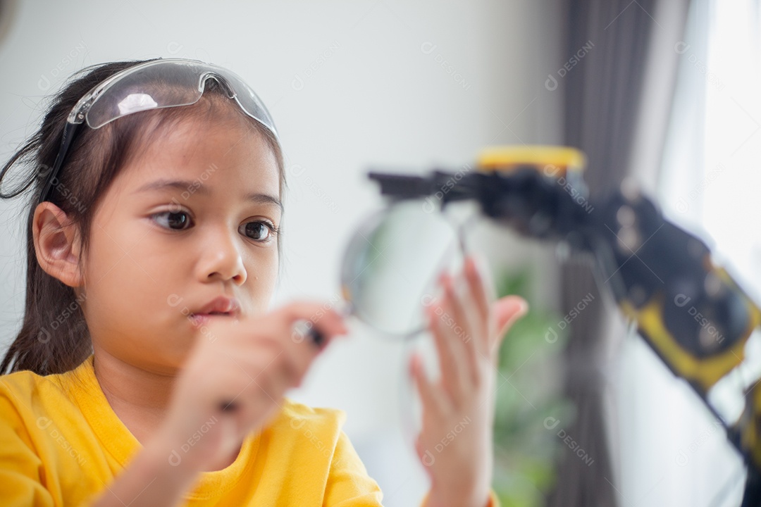 Conceito de educação STEM. Estudantes asiáticos aprendem em casa codificando braços de robôs em STEM