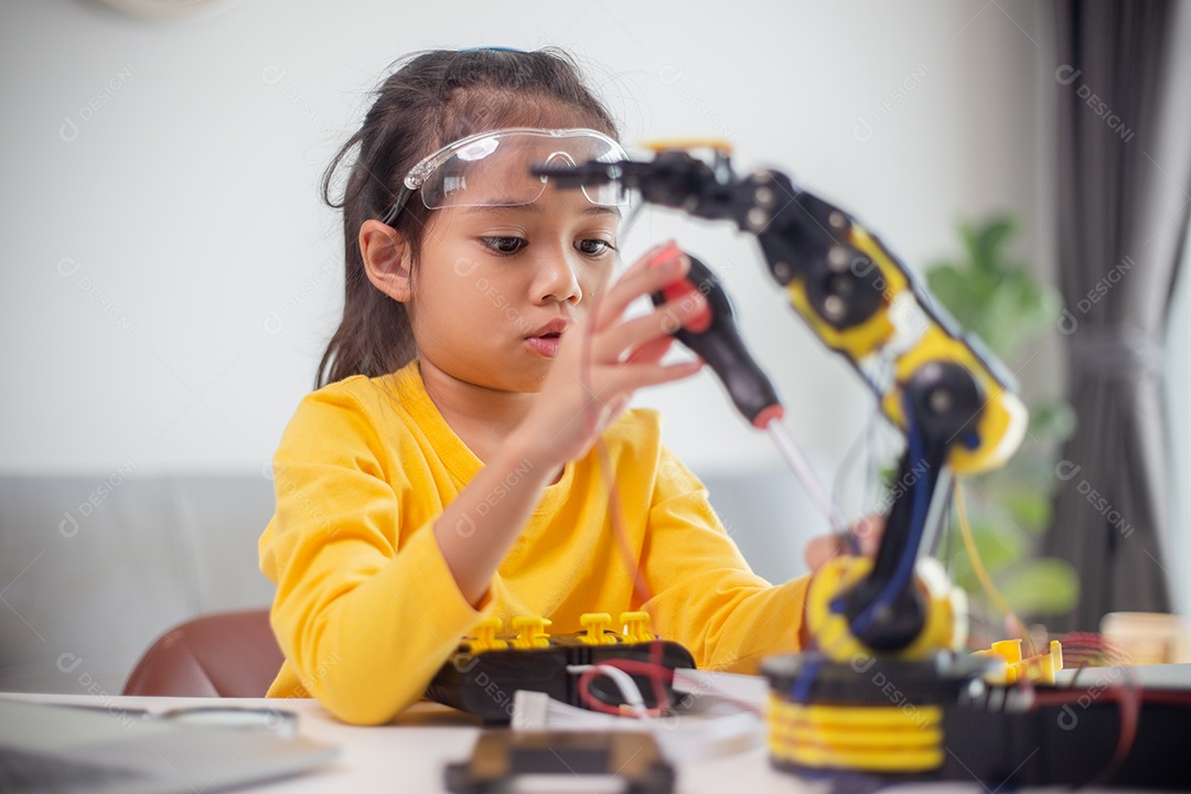 Conceito de educação STEM. Estudantes asiáticos aprendem em casa codificando braços de robôs em STEM