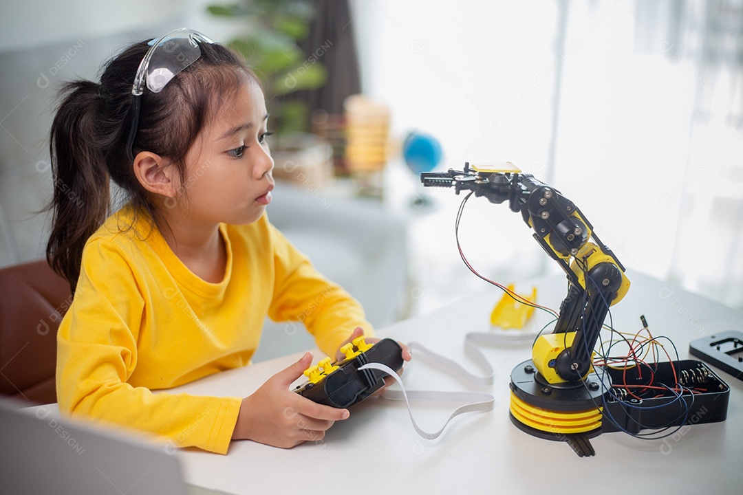 Conceito de educação STEM. Estudantes asiáticos aprendem em casa codificando braços de robôs em STEM