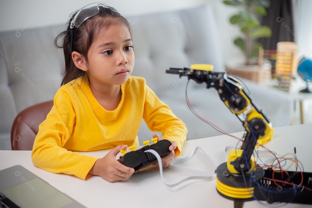 Conceito de educação STEM. Estudantes asiáticos aprendem em casa codificando braços de robôs em STEM