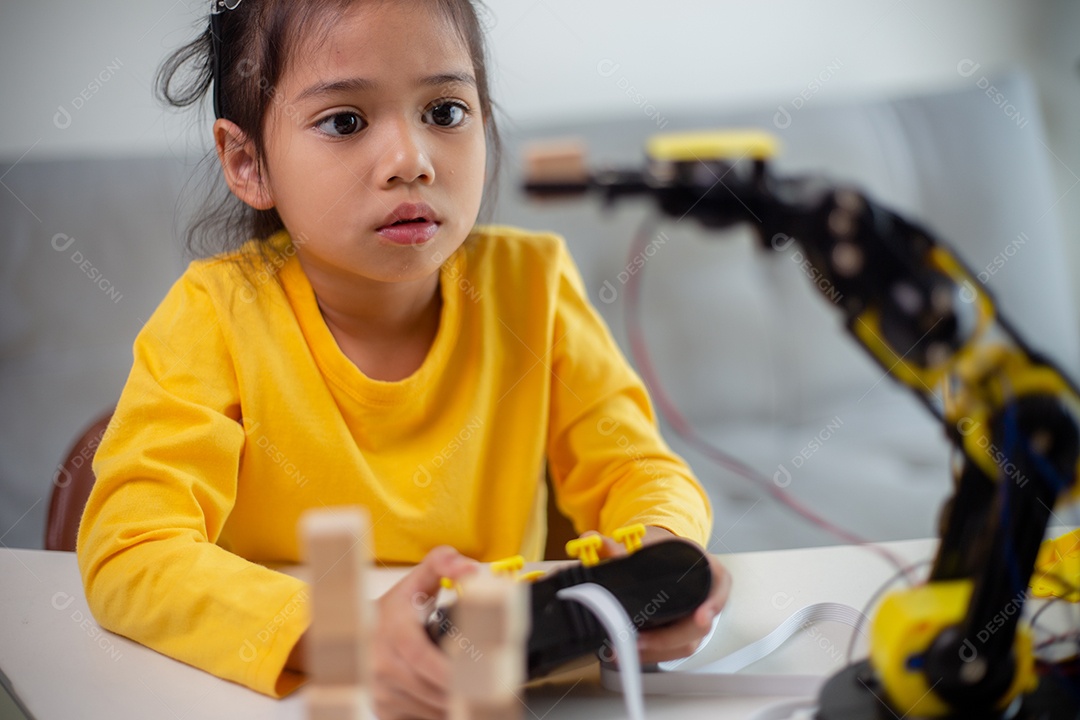 Conceito de educação STEM. Estudantes asiáticos aprendem em casa codificando braços de robôs em STEM