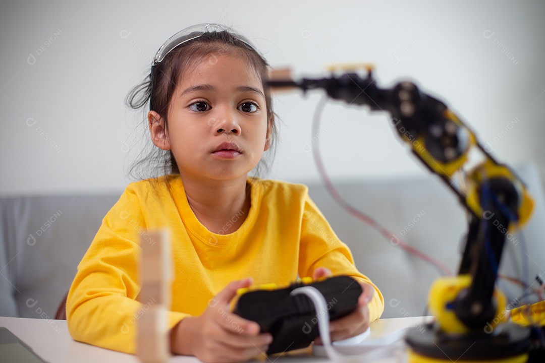 Conceito de educação STEM. Estudantes asiáticos aprendem em casa codificando braços de robôs em STEM