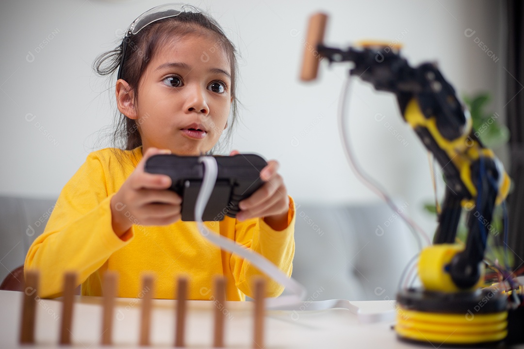 Conceito de educação STEM. Estudantes asiáticos aprendem em casa codificando braços de robôs em STEM