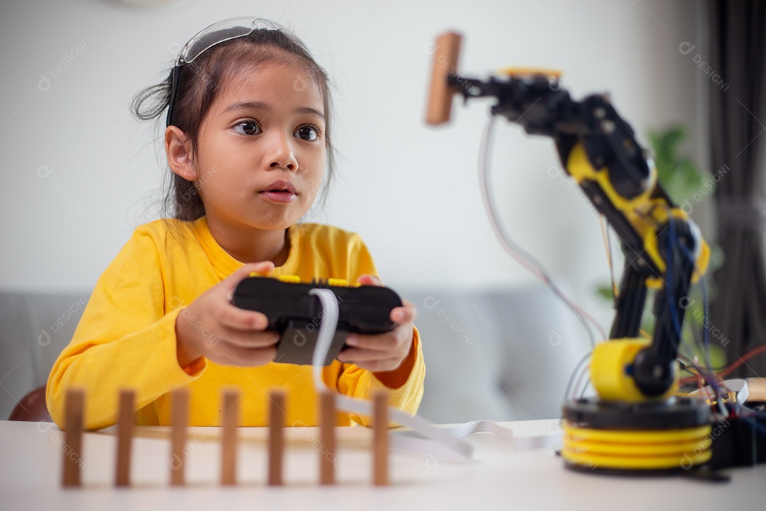 Conceito de educação STEM. Estudantes asiáticos aprendem em casa codificando braços de robôs em STEM