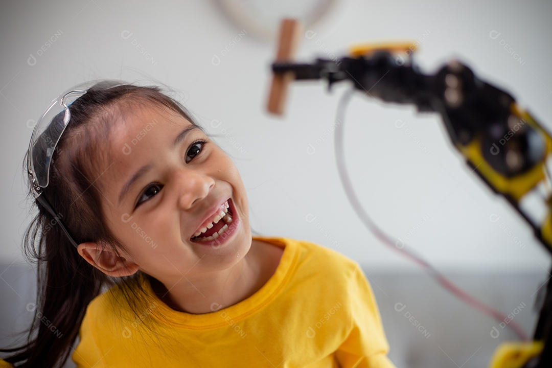Conceito de educação STEM. Estudantes asiáticos aprendem em casa codificando braços de robôs em STEM