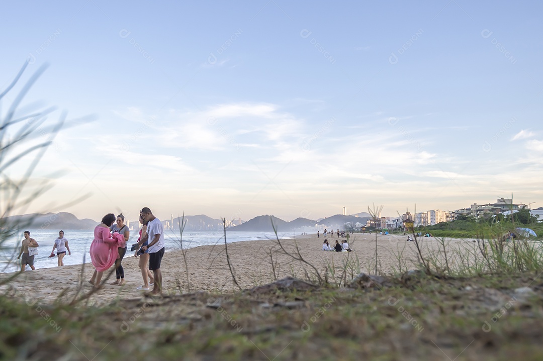 Praia brava em itajai-sc brasil com a cidade de balneário comboriu ao fundo e gente curtindo a praia conhecida por suas ondas altas.