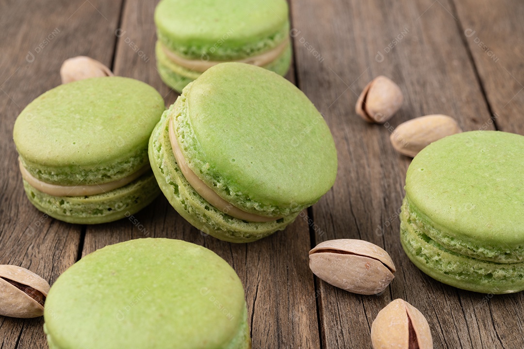 Macarons de pistache sobre mesa de madeira