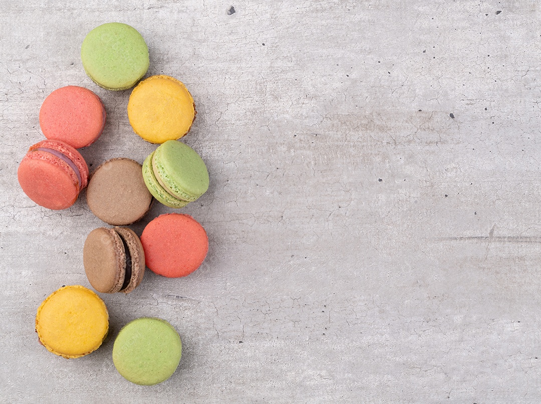 Macarons variados sobre fundo rústico com espaço de cópia.