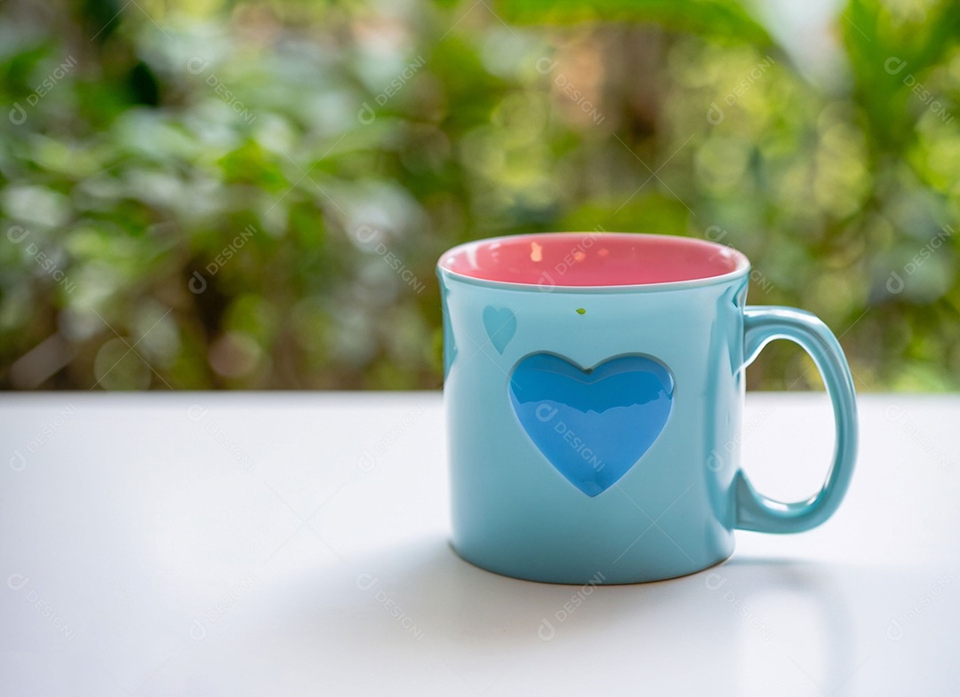 Xícara azul com coração sobre a mesa