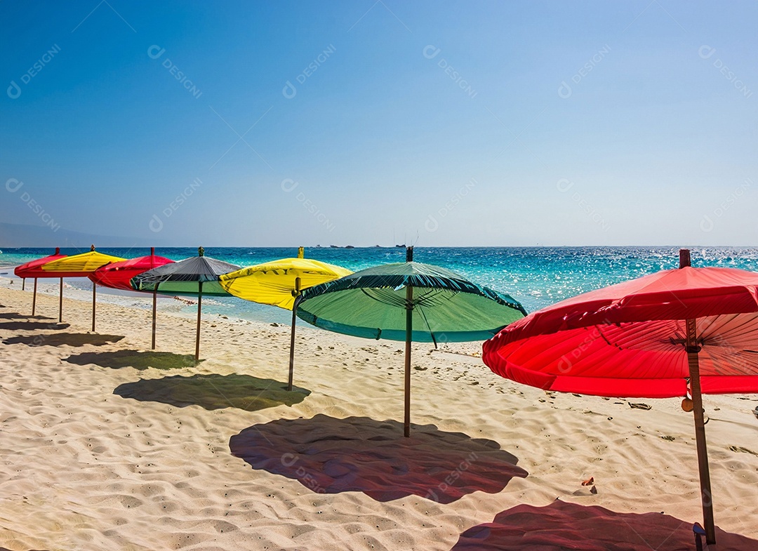 Guarda-sol coloridos na areia da praia