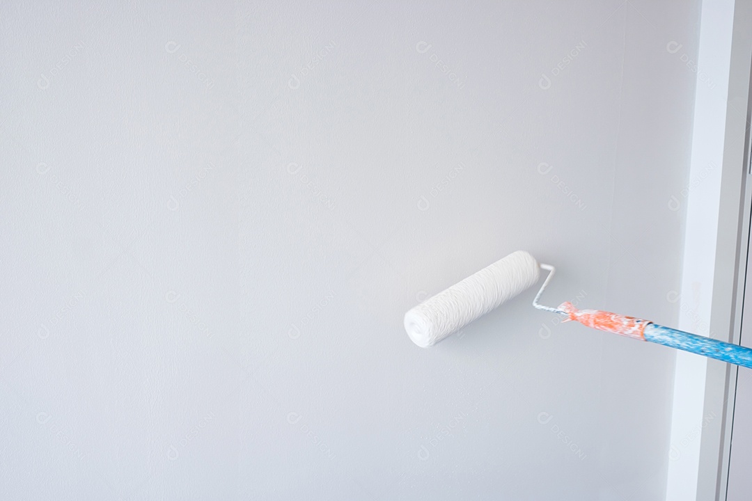 homem pintor com pincel de rolo de pintura pintando a parede.