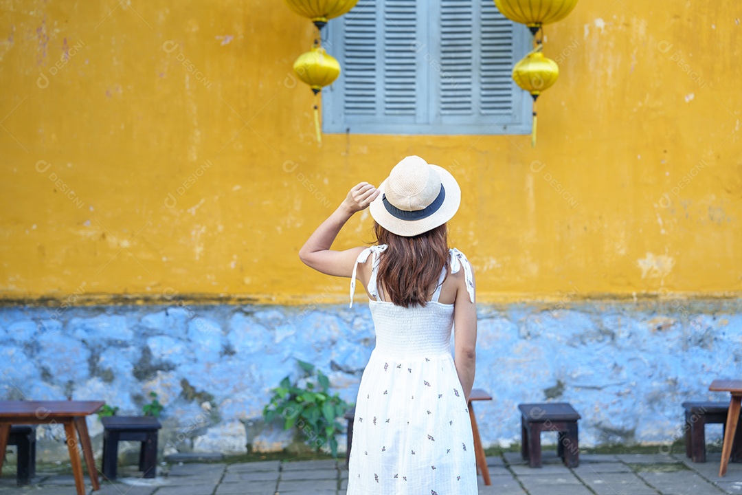 viajante feliz passeando em Hoi Uma cidade antiga no centro do Vietnã, mulher com vestido e chapéu viajando.
