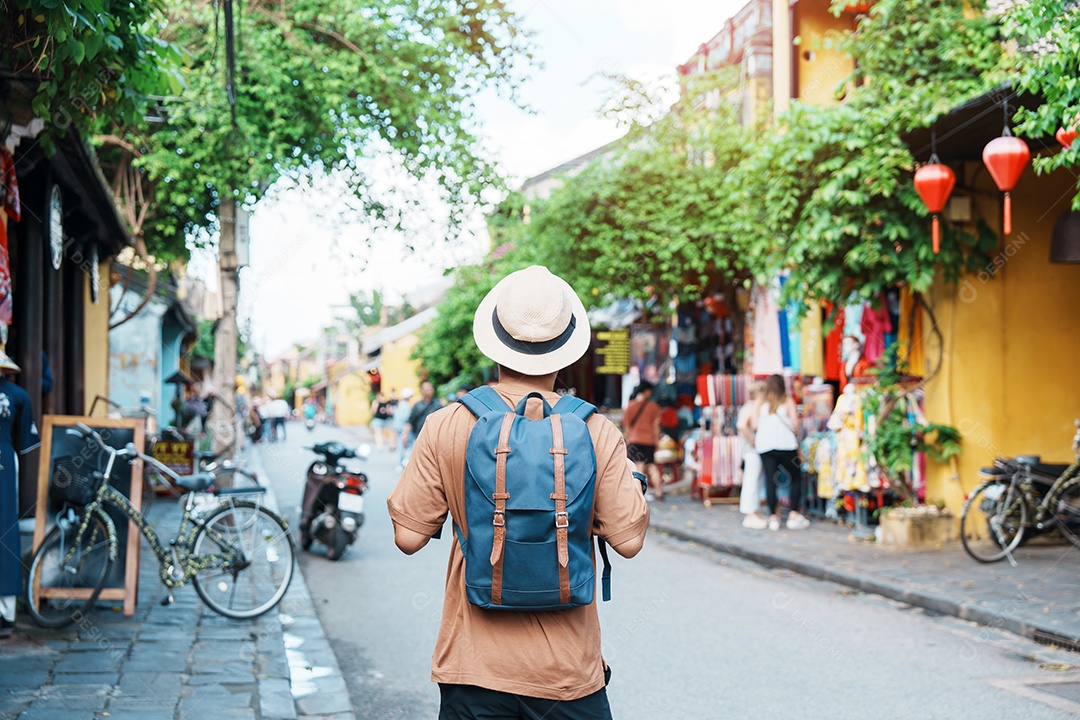 feliz viajante solitário visitando Hoi Uma cidade antiga no centro do Vietnã, homem viajando com mochila e chapéu.