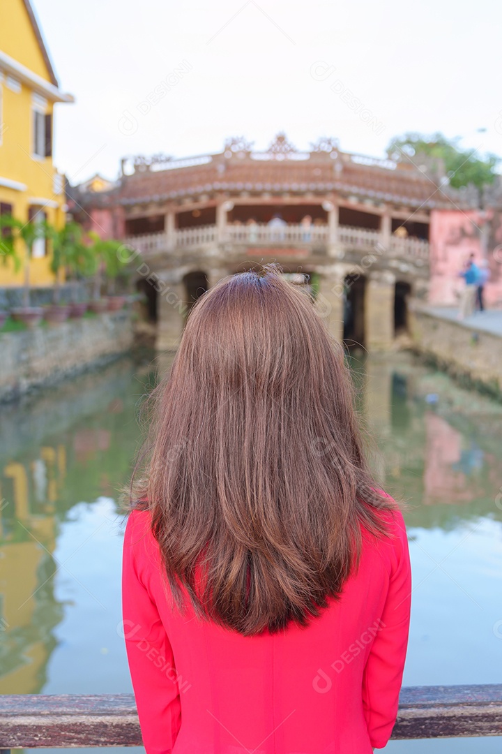 Mulher feliz usando vestido vietnamita Ao Dai, viajante asiático passeando em Hoi An, cidade antiga no centro do Vietnã.