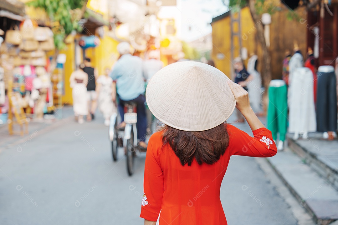 Mulher feliz usando vestido vietnamita Ao Dai, viajante asiático passeando em Hoi An, cidade antiga no centro do Vietnã.