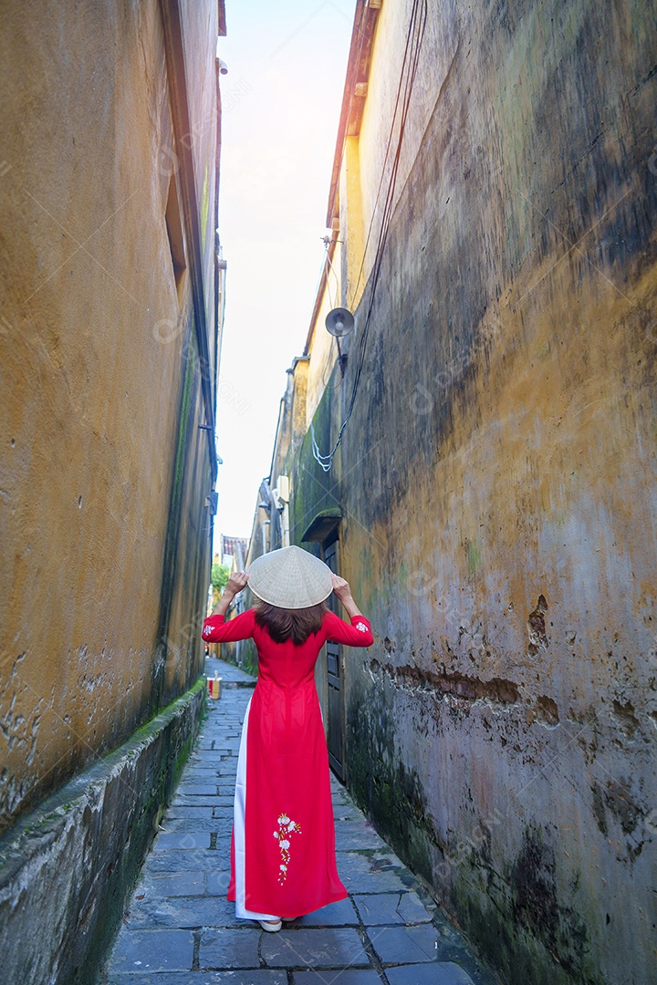 Mulher feliz usando vestido vietnamita Ao Dai, viajante asiático passeando em Hoi An, cidade antiga no centro do Vietnã.