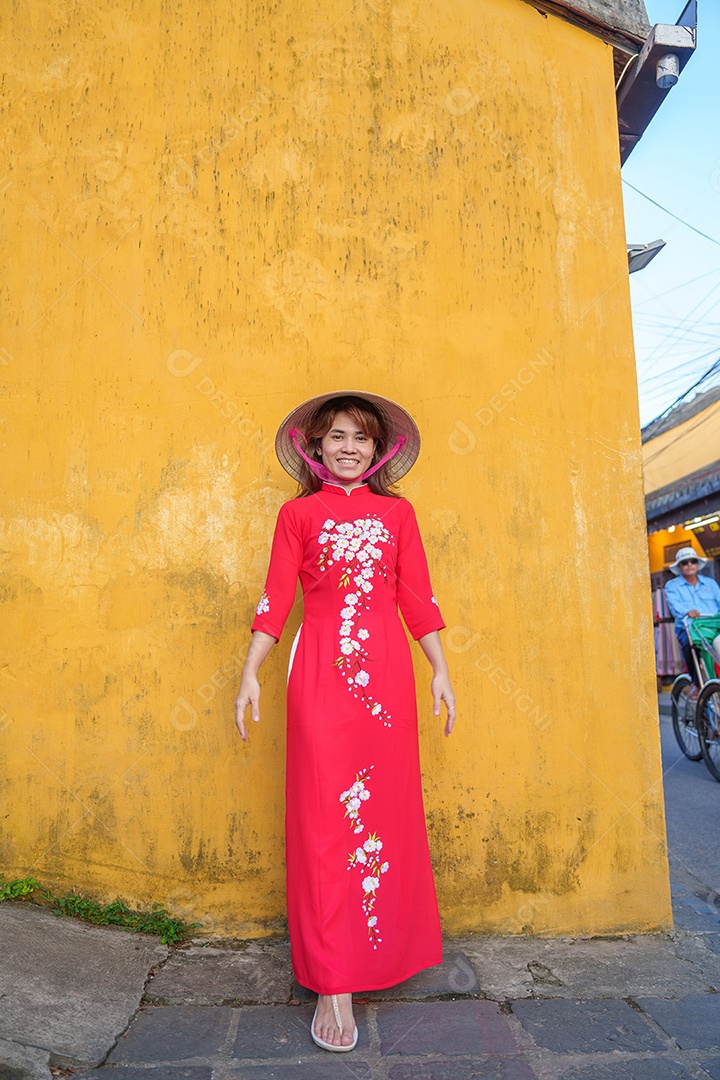Mulher feliz usando vestido vietnamita Ao Dai, viajante asiático passeando em Hoi An, cidade antiga no centro do Vietnã.