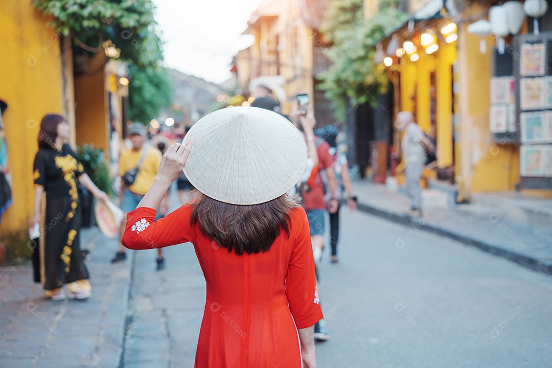 Mulher feliz usando vestido vietnamita Ao Dai, viajante asiático passeando em Hoi An, cidade antiga no centro do Vietnã.