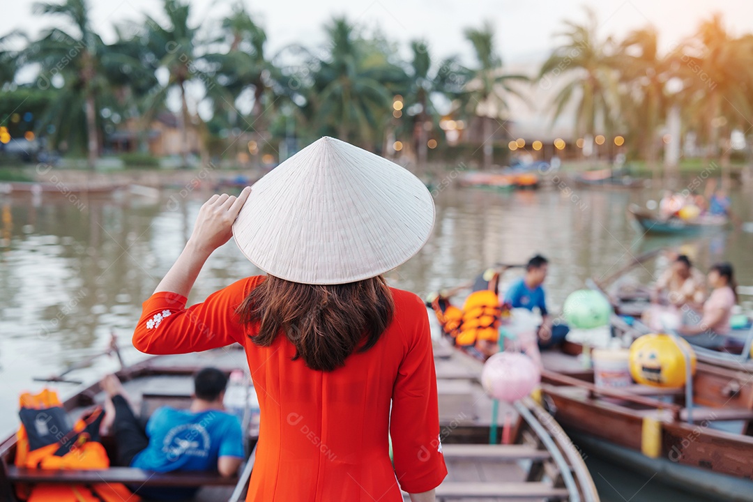 Mulher feliz usando vestido vietnamita Ao Dai, viajante asiático passeando em Hoi An, cidade antiga no centro do Vietnã.