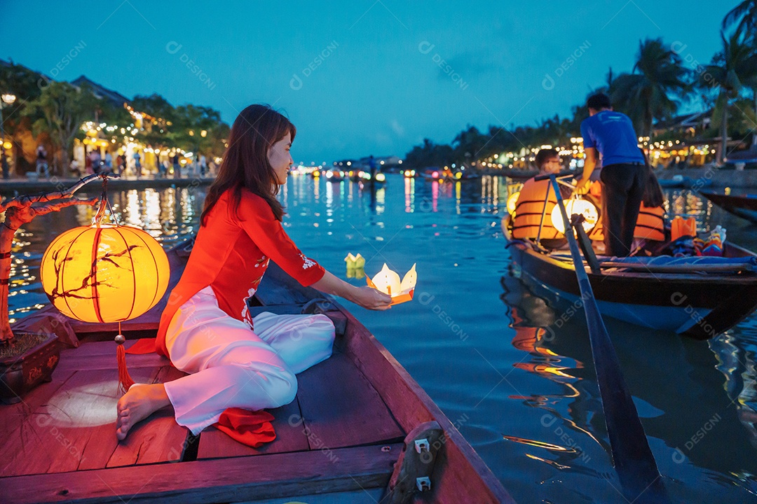 Mulher feliz usando vestido vietnamita Ao Dai, viajante asiático passeando em Hoi An, cidade antiga no centro do Vietnã.