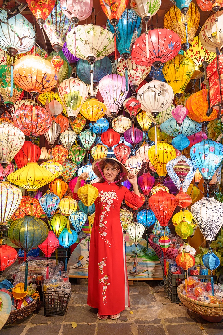 Mulher feliz usando vestido vietnamita Ao Dai, viajante asiático passeando em Hoi An, cidade antiga no centro do Vietnã.