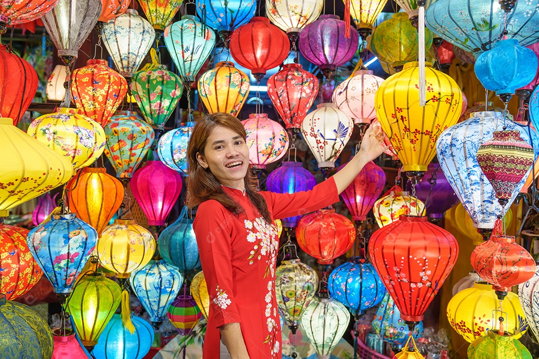 Mulher feliz usando vestido vietnamita Ao Dai, viajante asiático passeando em Hoi An, cidade antiga no centro do Vietnã.