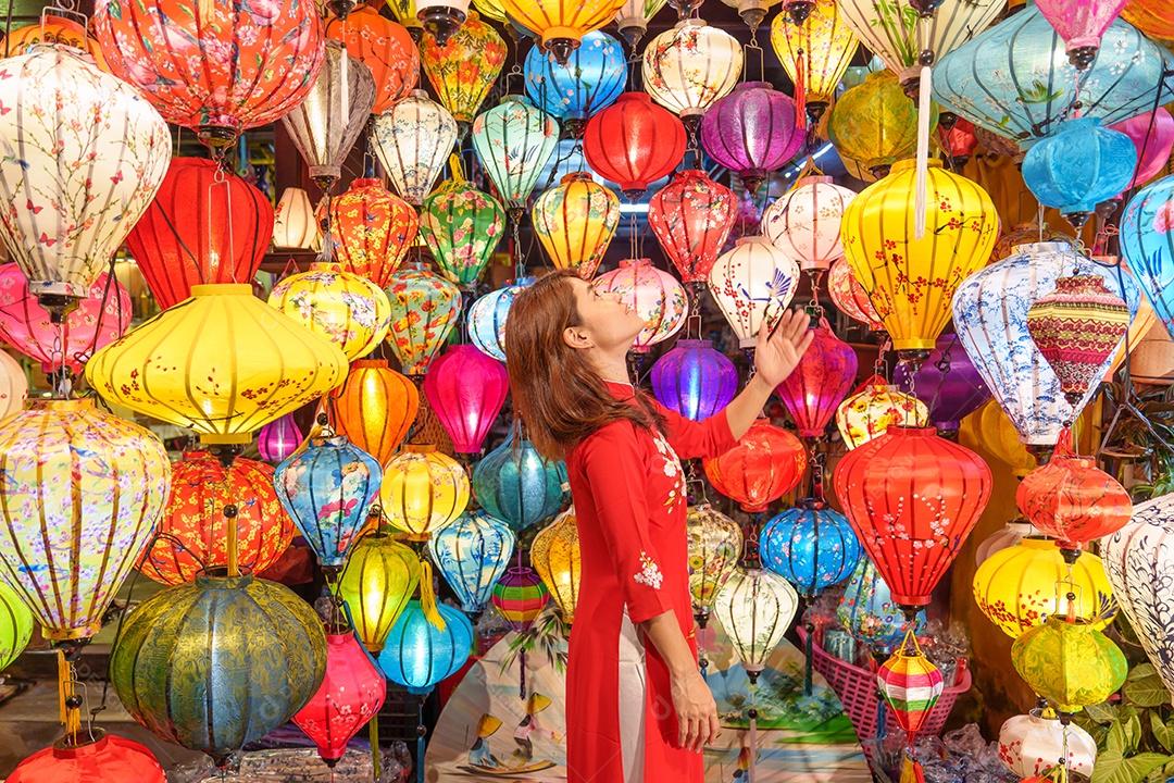 Mulher feliz usando vestido vietnamita Ao Dai, viajante asiático passeando em Hoi An, cidade antiga no centro do Vietnã.