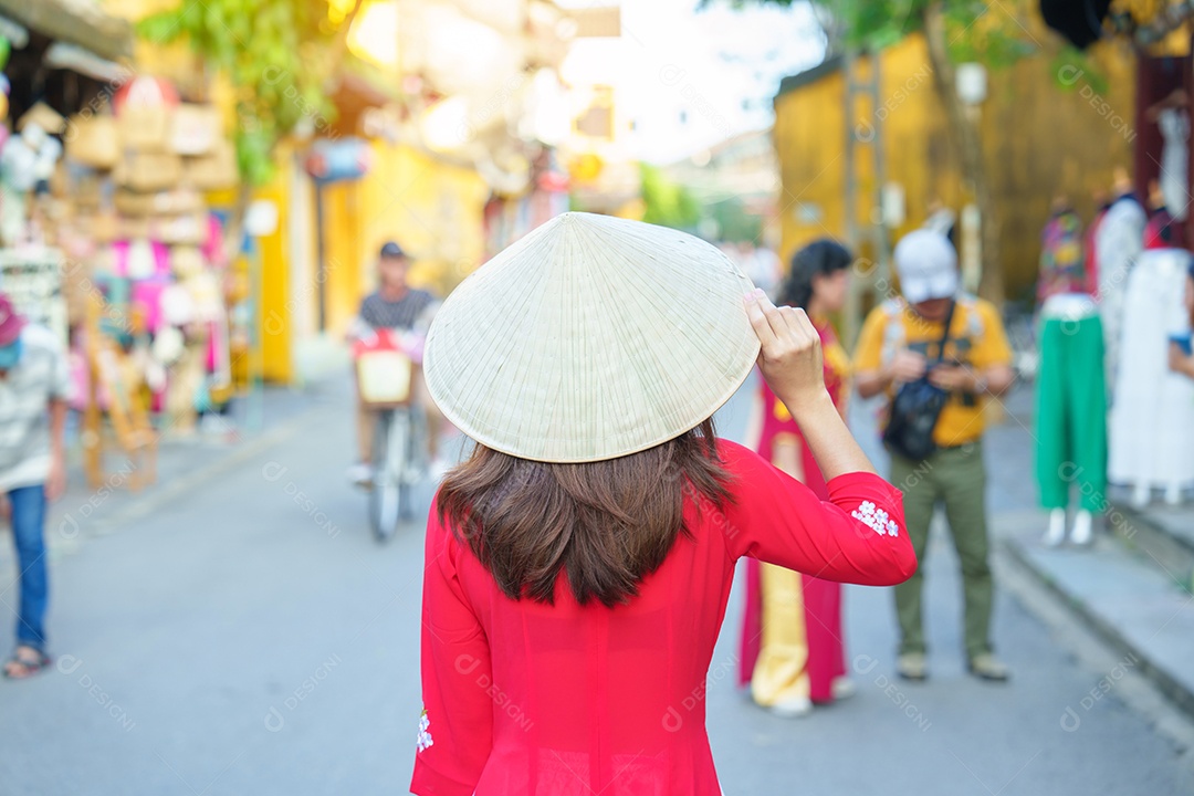 Mulher feliz usando vestido vietnamita Ao Dai, viajante asiático passeando em Hoi An, cidade antiga no centro do Vietnã.