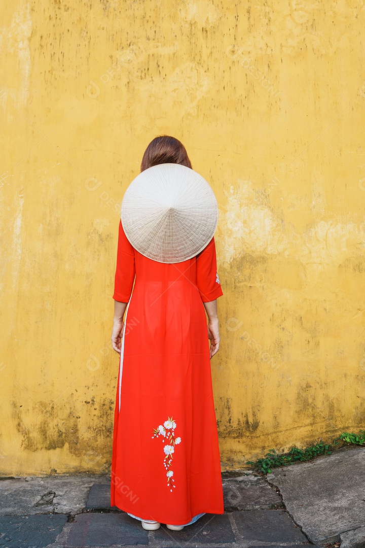 mulher feliz usando vestido vietnamita Ao Dai, viajante asiático passeando em Hoi An, cidade antiga no centro do Vietnã.